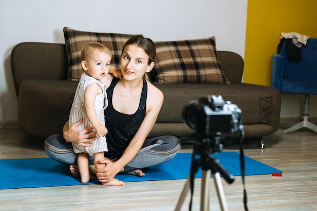 Mama blogerka nagrywa wideo kamerą ze swoją małą córeczką w domu