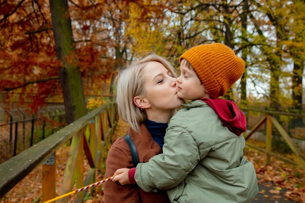 Mama całuje syna w jesiennym parku