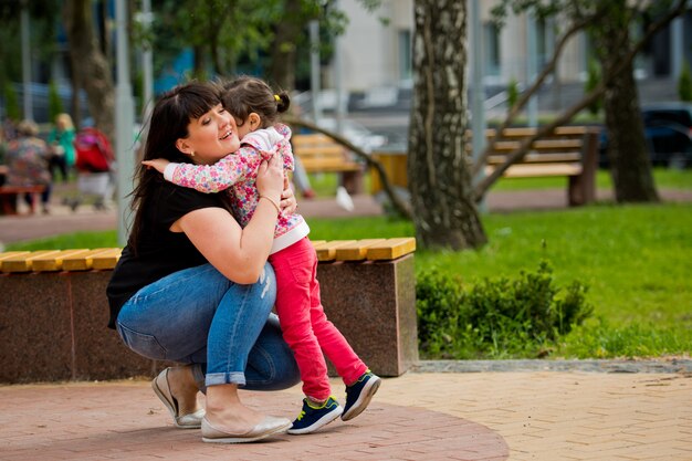 Mama dzwoni do swojej córeczki, wyciągając do niej ręce