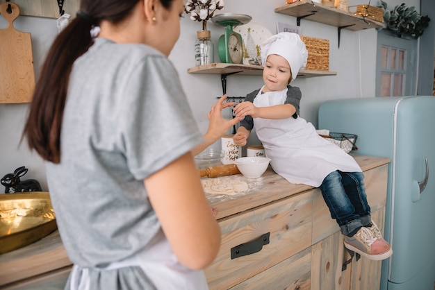 mama i chłopiec przygotowują ciasto na świąteczne ciasteczka