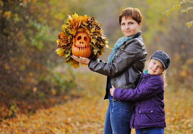 Mama I Córeczka Na Tle Jesiennego Lasu Uśmiechnięta Przytulająca Się I Trzymająca Lampion Dyni Jacka - Symbol święta Halloween.