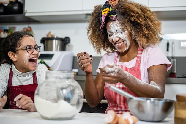 Mama i córka bawią się mąką przygotowując w domu słodycze chwile zabawy i zabawy między rodzicem a córką w kuchni