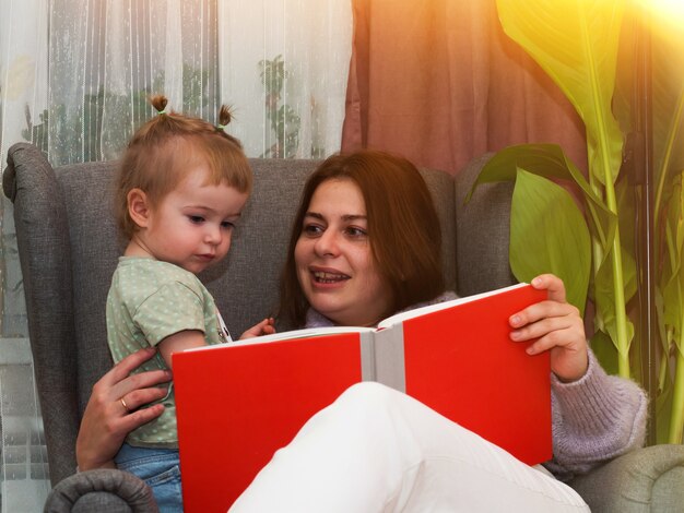 Mama i córka czytają książkę w stylu życia na krześle