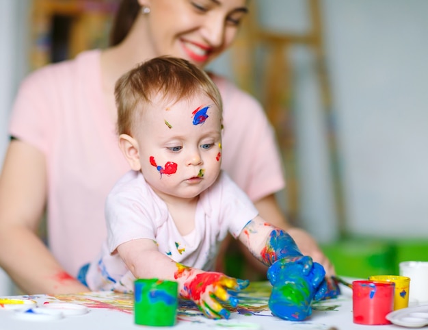 Mama i córka malują na płótnie w szkole rysunku.