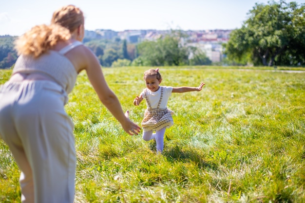 Mama i córka śmieją się i bawią w parku koncepcja szczęśliwej rodzinnej przyjaźni i miłości