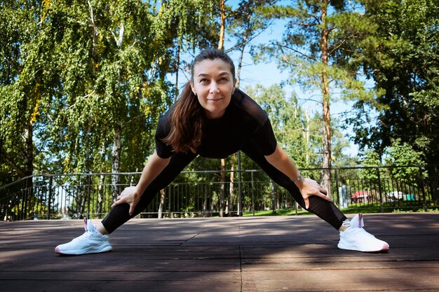 mama i córka w strojach sportowych w słoneczny letni dzień na nabrzeżu w parku uprawiają fitness