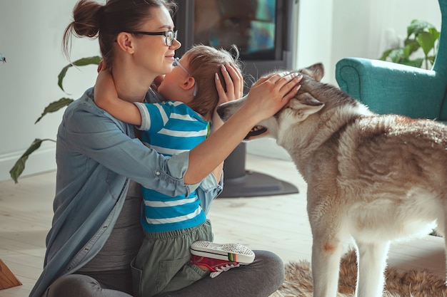 Mama i dziecko bawią się i bawią z psem w domu