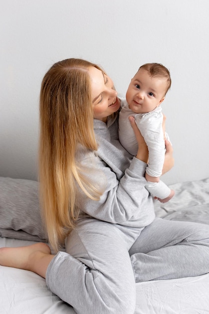 Mama I Dziecko Bawią Się Na łóżku Matka I Syn Szczęśliwa Rodzina Piękna Blondynka I Słodkie Dziecko W Domu