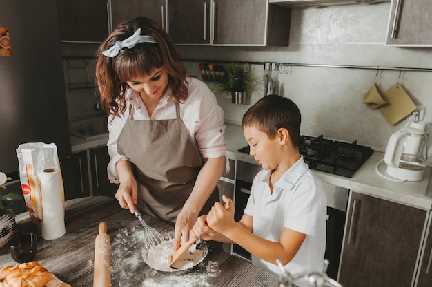 Mama i dziecko przygotowują w kuchni tort urodzinowy na Dzień Matki, serię zdjęć codziennego stylu życia we wnętrzu z prawdziwego życia