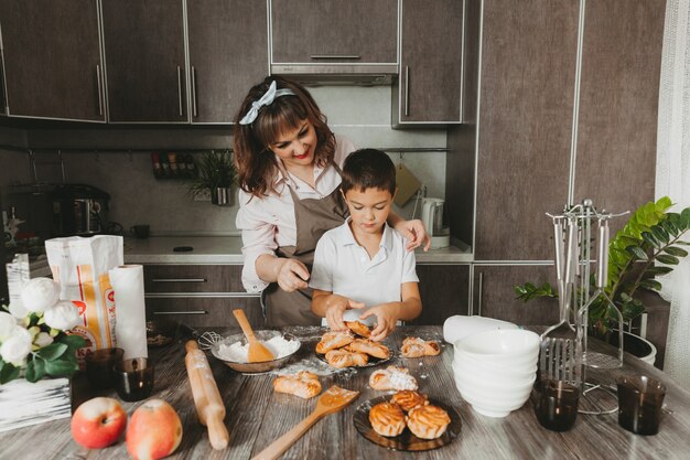 Mama i dziecko przygotowują w kuchni tort urodzinowy na Dzień Matki, serię zdjęć codziennego stylu życia we wnętrzu z prawdziwego życia