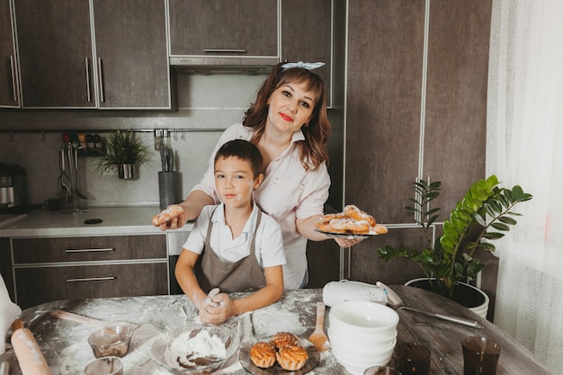 Mama i dziecko przygotowują w kuchni tort urodzinowy na Dzień Matki, serię zdjęć codziennego stylu życia we wnętrzu z prawdziwego życia