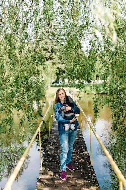 Mama i dziecko stoją na drewnianym moście prowadzącym przez rzekę lub jezioro na wyspie