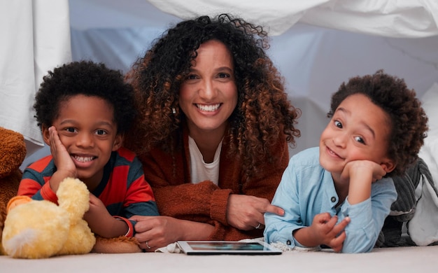Mama i jej chłopcy Ujęcie młodej matki korzystającej z cyfrowego tabletu z dziećmi w domu