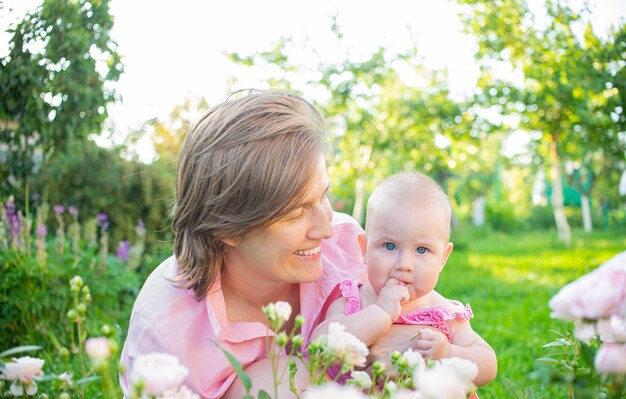 Mama i jej córeczka śmieją się i bawią na świeżym powietrzu w ogrodzie.