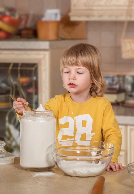 Zdjęcie mama i jej małe dziecko gotują w kuchni.