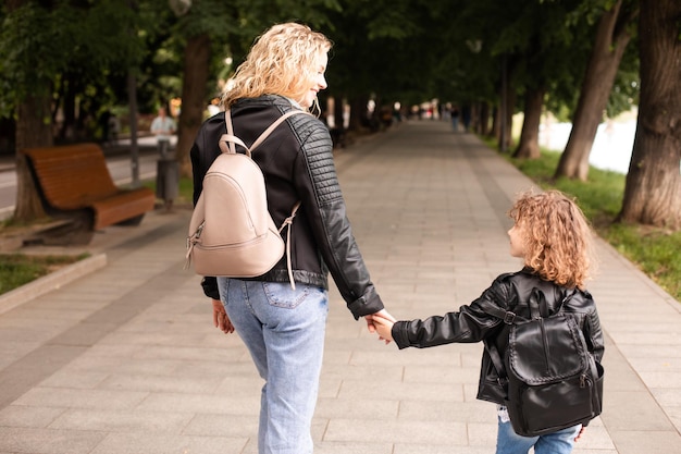 Mama i mała dziewczynka spacerują po mieście trzymają się za ręce