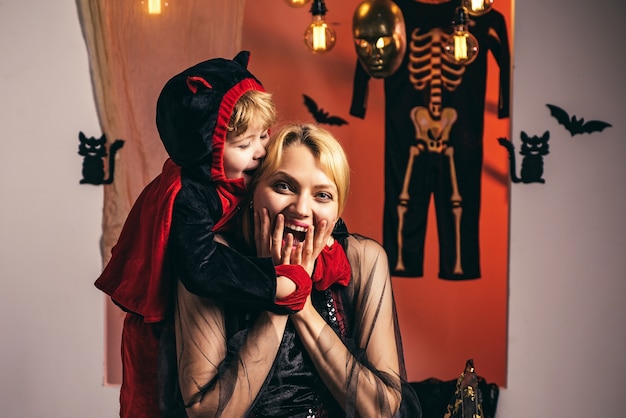 Zdjęcie mama i mały chłopiec dziecko w pobliżu dekoracji dyni i halloween