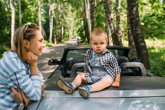 Zdjęcie mama i mały syn w samochodzie kabriolecie letnia rodzinna wycieczka na przyrodę