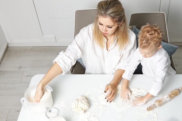 Mama i syn gotują razem w białej kuchni z ciasta