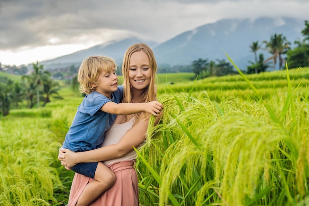 Mama i syn podróżujący na pięknych tarasach ryżowych Jatiluwih na tle słynnych wulkanów na Bali, Indonezja Podróżowanie z dziećmi koncepcja