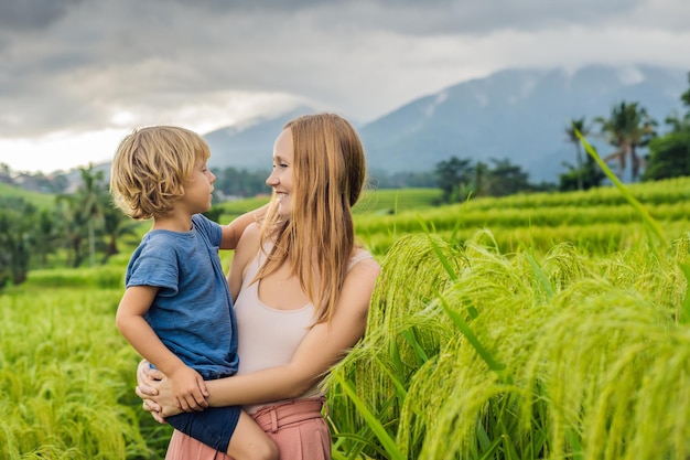 Mama i syn podróżujący na pięknych tarasach ryżowych Jatiluwih na tle słynnych wulkanów na Bali, Indonezja Podróżowanie z dziećmi koncepcja