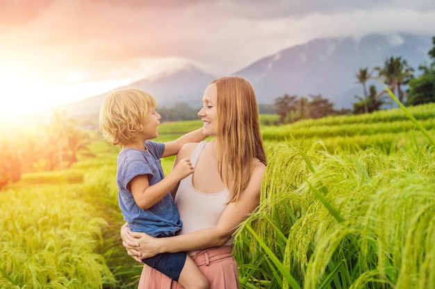 Mama i syn podróżujący na pięknych tarasach ryżowych Jatiluwih na tle słynnych wulkanów na Bali, Indonezja Podróżowanie z koncepcją dzieci ze światłem słonecznym