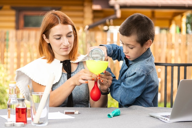 Mama I Syn Przeprowadzają W Domu Fizyczne Eksperymenty. Doświadczenie Z Dzieckiem O Tym, Która Z Kulek Jest Pusta Lub Z Wodą, Szybciej Wybuchnie Z Ognia. Krok 2