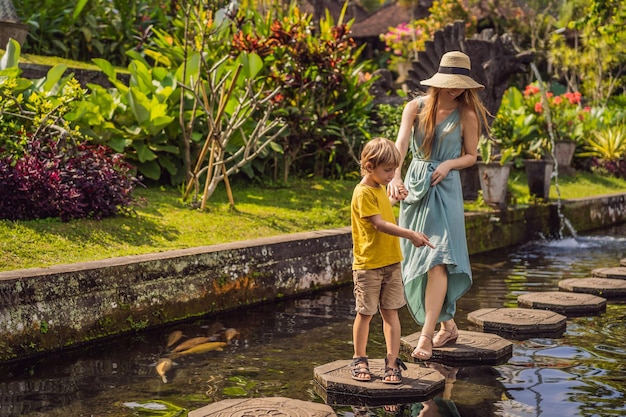 Mama i syn turyści w Taman Tirtagangga Pałac wodny Park wodny Bali Indonezja Podróżowanie z dziećmi koncepcja Miejsce przyjazne dzieciom