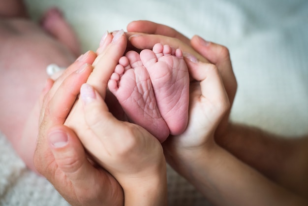 mama i tata trzymają ręce dziecka