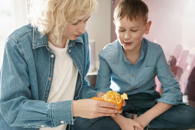 Mama Obiera Mandarynkę Dla Swojego Ciekawskiego Syna W Kuchni