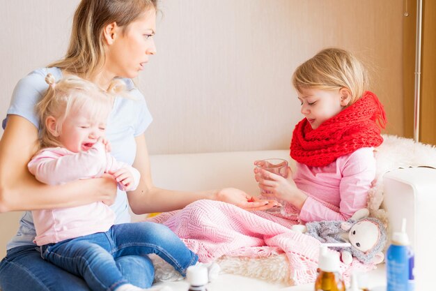 Mama podaje swojemu choremu dziecku tabletki