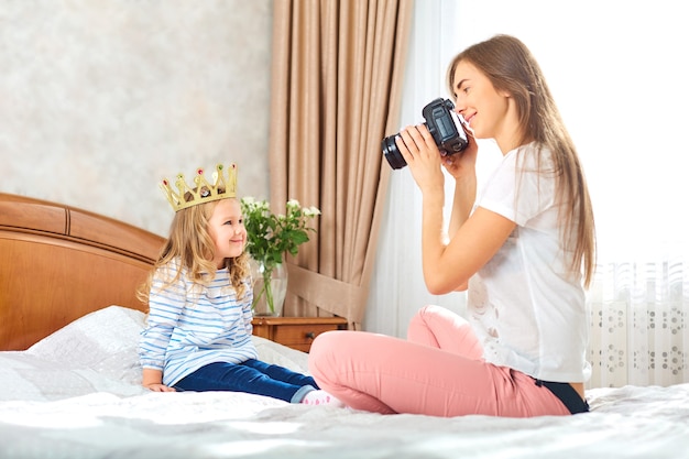 Mama robi zdjęcia swojemu dziecku w pokoju przy oknie