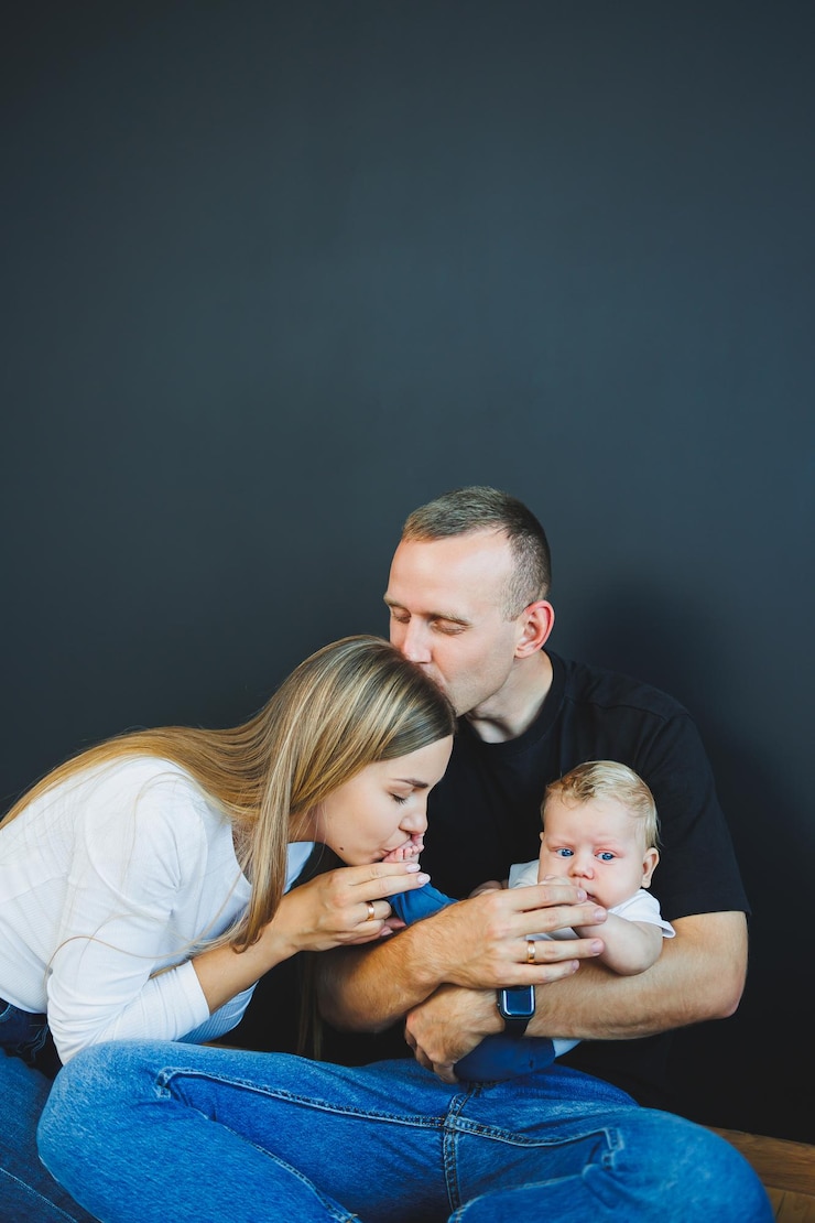 Zdjęcie mama, tata i nowo narodzony syn bawią się w domu. szczęśliwa para z dzieckiem.