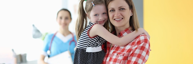 Zdjęcie mama trzyma małą dziewczynkę w ramionach na wizytę u lekarza