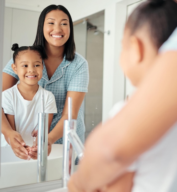 Mama uczy dziecko mycie rąk czyszczenie i woda dla zdrowej higieny wellness bezpieczeństwo i poranny styl życia Matka dziewczyna dziecko i uczące się lustro w łazience pielęgnacja skóry dla ochrony przed bakteriami