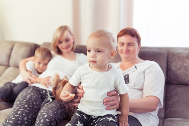 Mama w ciąży i jej dzieci, dwójka synów, spędzają razem czas w domu