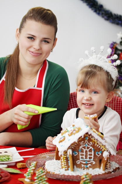 Zdjęcie mama z córką przygotowują imbirowy domek