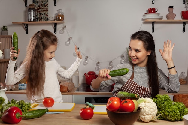 Mama z córką przygotowują sałatkę jarzynową i bawią się w kuchni.