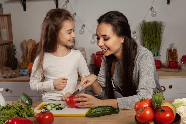 Mama Z Córką Przygotowują Sałatkę Jarzynową I Bawią Się W Kuchni.