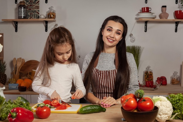 Mama z córką przygotowują sałatkę jarzynową i bawią się w kuchni.