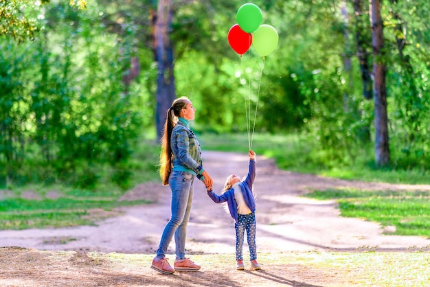 Mama z córką trzyma balony w lesie Letni słoneczny dzień