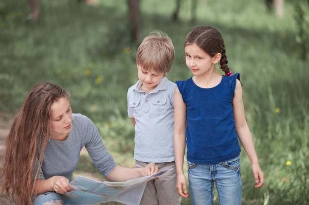 Mama z dwójką dzieci patrząca na papierową mapę