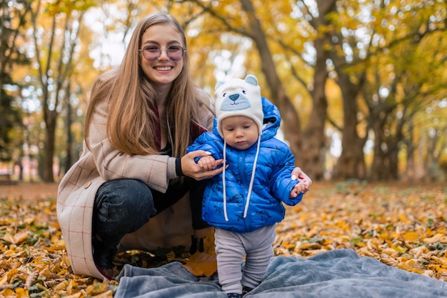 Mama z jej pomocą uczy dziecko chodzić Niemowlę