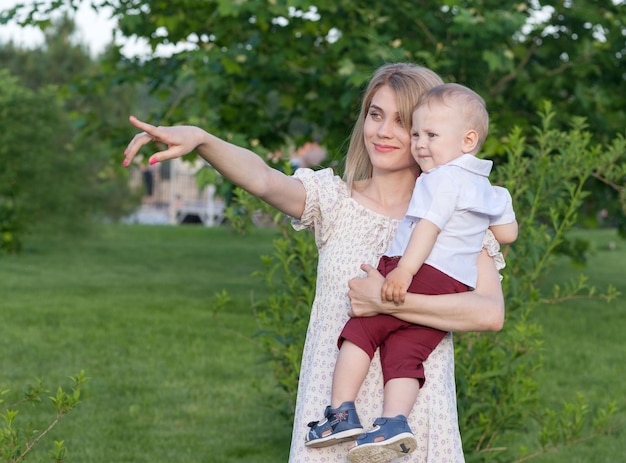 mama z małym dzieckiem bawi się na zielonym trawniku