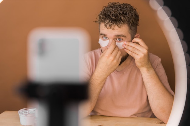 Man make up vlogger nagrywający audycję o kosmetykach i samouczkach dla wizażystki