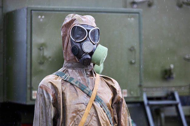 Zdjęcie manekin ubrany w brązowy chemiczny kombinezon ochronny i czarną maskę przeciwgazową
