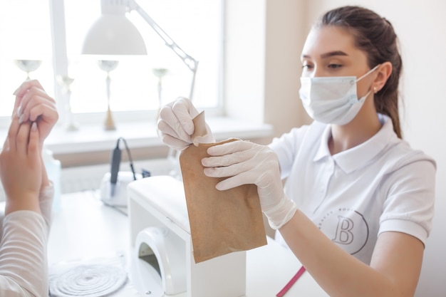 Manikiurzystka robi manicure w salonie. Mistrz obsługujący swojego klienta. Procedura pielęgnacji paznokci.