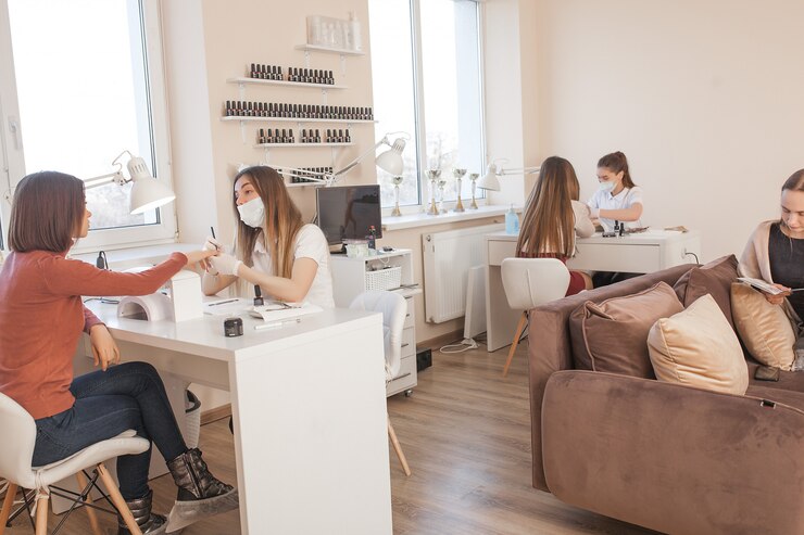 Manikiurzystka robi manicure w salonie. Mistrz obsługujący swojego klienta. Procedura pielęgnacji paznokci.