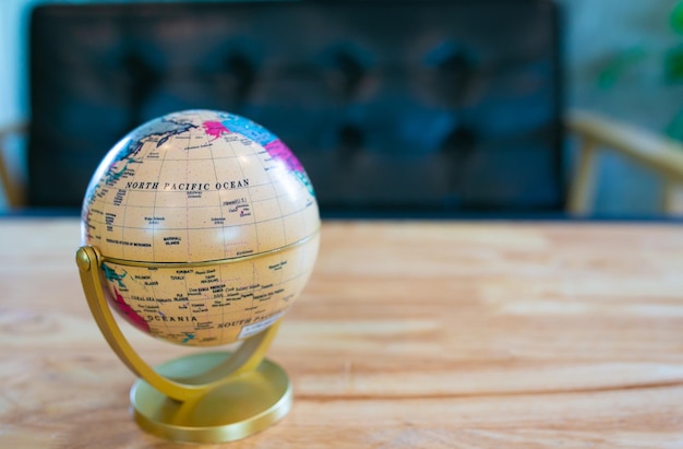 Mapa świata mały glob umieścić na drewnianym stole w kawiarni.