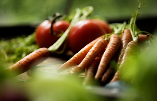 Zdjęcie marchewka i pomidor wśród zielonego warzywa